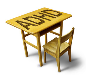 ADHD Concept for hyperactivity disorder and attention deficit behavior as a school desk with the letters carved into the wooden table as a healthcare symbol for childhood mental health issues.